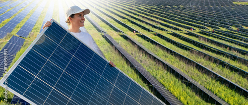 Woman wearing white cap and t-shirt holds solar panel.