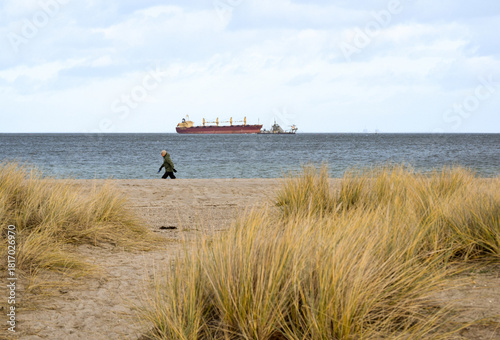 Photography man walking on the beach, copenhagen
