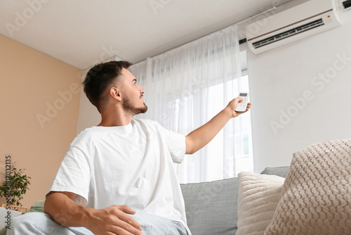 Young man turning on air co...