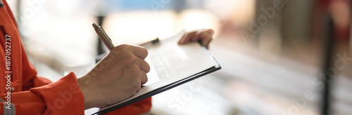 Close-up at supervisor hand is using pen to checking on project risk assessment form to evaluate serverity level. Industrial or business working scene. 