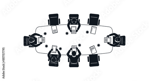 A top down view of people seated around an oval table with laptops