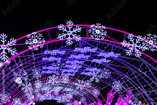 Illuminated tunnel with glowing snowflakes and purple festive lights