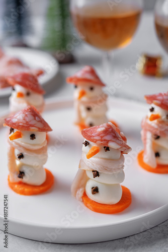 Mozzarella balls with sausage, bacon and carrot slices in the form of snowman for Christmas holidays