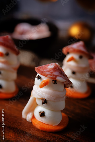 Mozzarella balls with sausage, bacon and carrot slices in the form of snowman for Christmas holidays