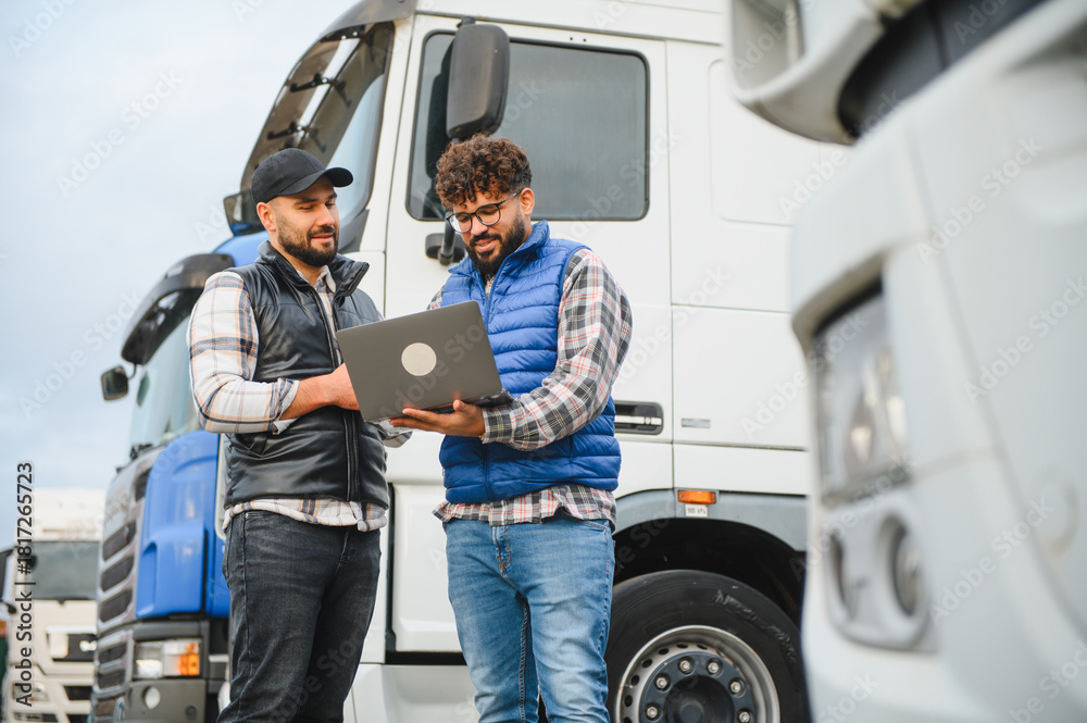 Naklejka premium Truck drivers discussing logistics using laptop at terminal