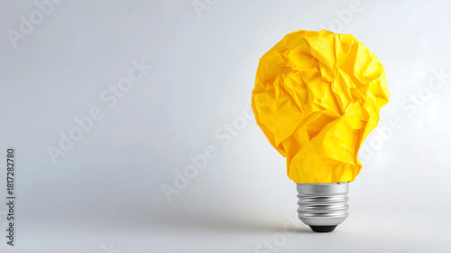 Crumpled yellow paper light bulb as a concept for creativity and ideas with copy space
