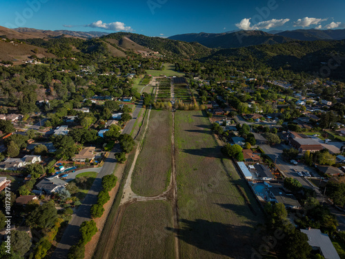 Aerial panoramic view of long abandoned carmel valley airstrip. Pilots view in the middle of residential housing.  