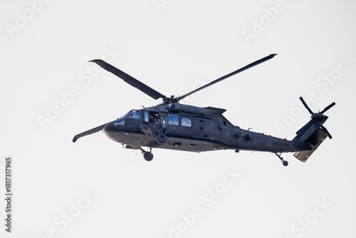 Wallpaper Mural Military utility helicopter in midair with extended landing gear, front sensors and tail rotor visible during flight operation against bright open sky Torontodigital.ca