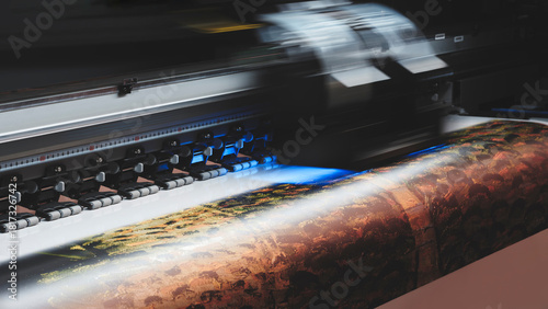 A moving working industrial wide format printer prints a color picture on paper.