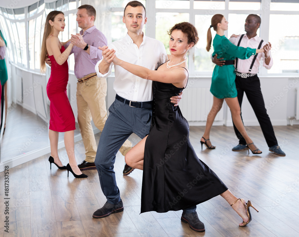 Fototapeta premium Pair of woman and man enjoying of sensual tango dance in choreo class. Exciting hobby, active lifestyle, passion for dancing and choreography
