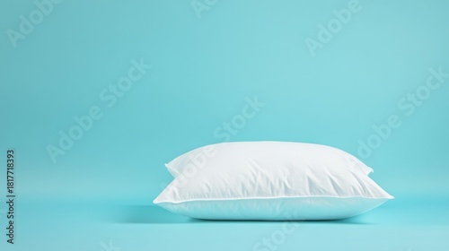 Plush white pillow against a serene blue background, evoking a sense of comfort and relaxation.