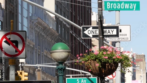 New York City Broadway street sign in Manhattan Midtown, United States. Urban road sign, traffic sign. Building architecture in Flatiron district. Crossroad with 5 fifth avenue. Subway metro globe.
