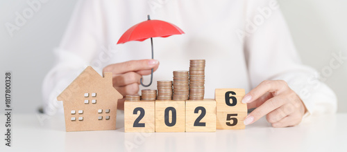 2025 end year to Happy New Year 2026 with red umbrella over money stack. Insurance, real estate, Home loan, tax, investment, mortgage, financial, savings, protection and safety