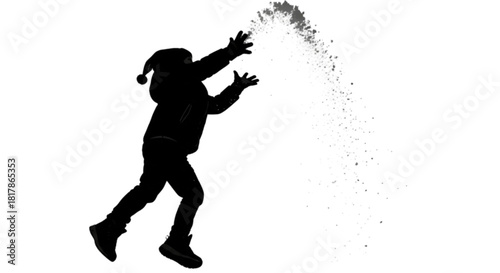 Silhouette of a joyful child in a winter hat throwing snow in the air.