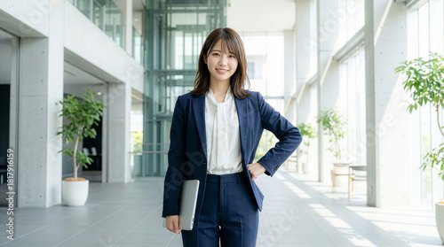 ノートパソコンを持つカジュアルスーツを着た笑顔の女性