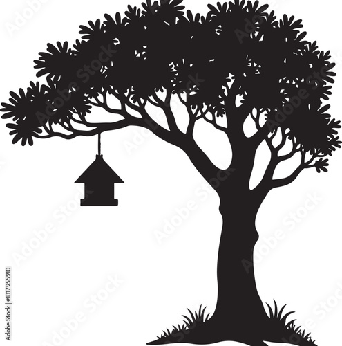 Black silhouette of a tree with a birdhouse and grass