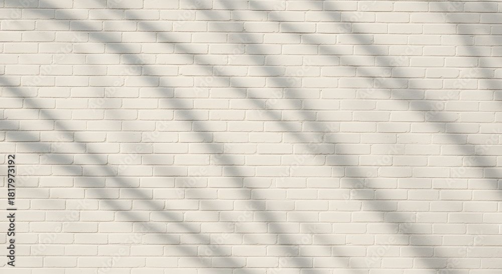 Obraz premium Subtle shadows dance across a textured, cream-colored brick wall, creating a minimalist backdrop.