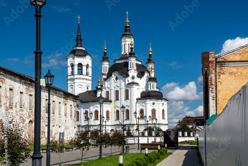 Fototapeta Naklejka Na Ścianę i Meble -  Church of Zachariah and Elizabeth, Tobolsk. A street in a recreation park in a small Siberian town, bathed in autumn sunshine. At the end of the street is a church. Tourism in Russia