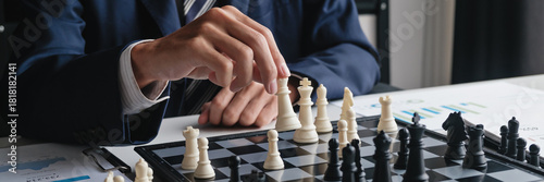 businessman moves chess pieces to execute winning business strategy