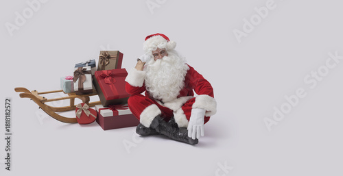 Santa Claus posing next to a small sleigh