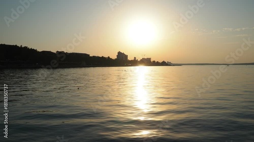 Witness the beauty of sunset above Lake Onega in Karelia. The sky glows with colors as the sun sets, and the water reflects its warm hues. Nature offers a peaceful moment. City embankment along shore