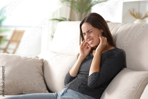 Stressed woman suffering jaw ache and complaining at home