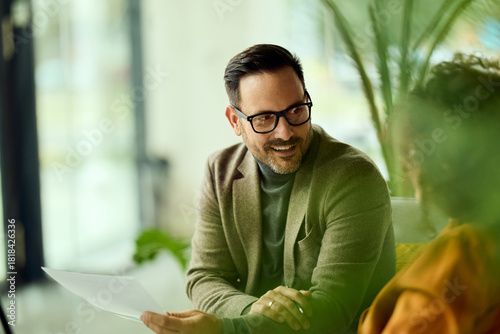 Confident Professional Man In Glasses Reviewing Documents In A Modern Office Setting