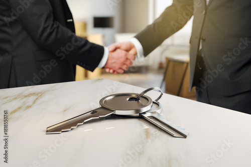 Businessmen handshake with house keys on marble table, symbolizing real estate deal or property agreement in modern office setting concept.