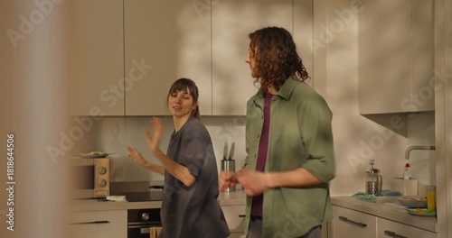A couple shares laughter and warmth in their stylish kitchen, preparing a meal while basking in the afternoon light