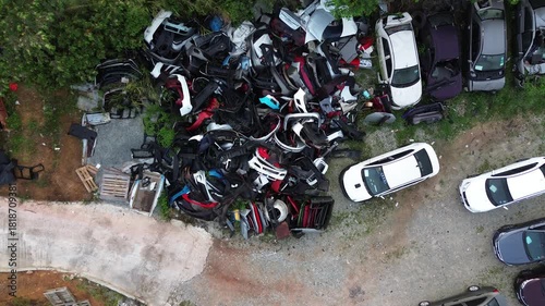 Drone shot showing industrial waste, including discarded car parts and salvage vehicles, highlighting pollution and recycling.