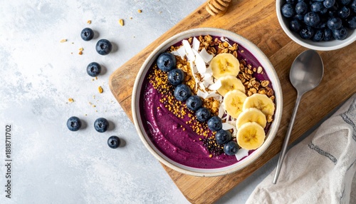 Acai breakfast superfoods smoothies bowl topped with bee pollen granola coconut flakes and blueberries. Overhead top view flat lay