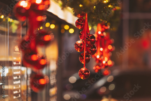 Festive red ornaments hanging in a cozy street decorated for the holiday season with warm lights glowing at night