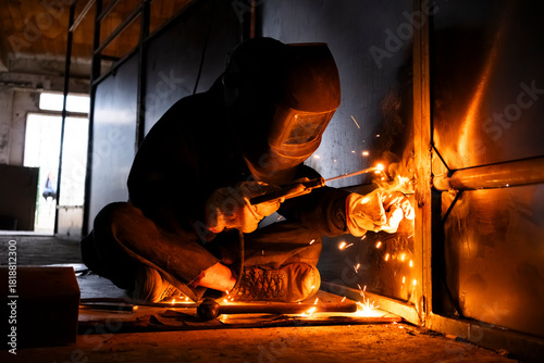 Anonymous welder working with shield and sparks flying