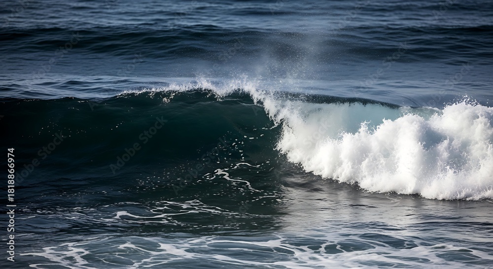 Fototapeta premium Powerful ocean wave cresting with dynamic white foam and sparkling spray against the deep blue sea surface