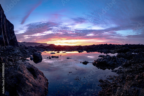 Scenic rocky coastline with vibrant sunset reflection