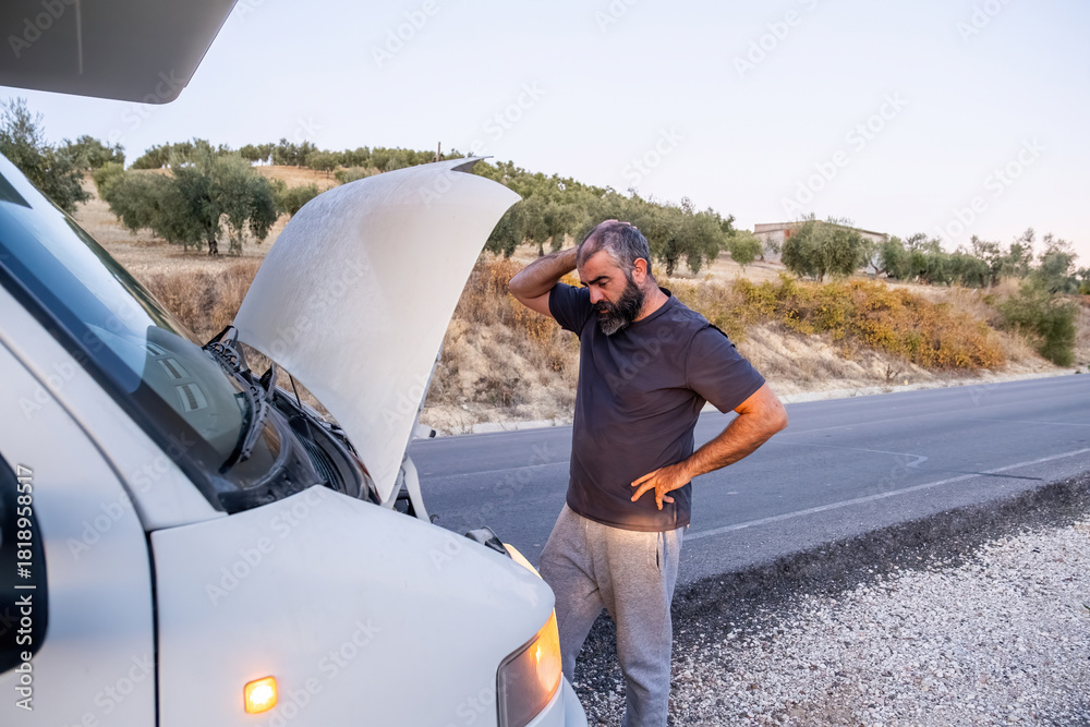 Fotografie Man frustrated by broken down camper van on roadside