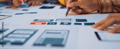 Canvas Print A dynamic team collaborates on user interface design using sketches and wireframes on a shared workspace, highlighting teamwork and creativity in digital project development