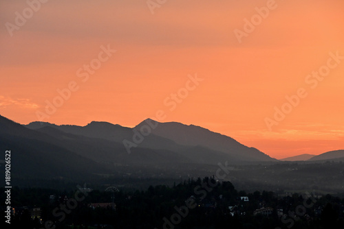 Fototapeta Naklejka Na Ścianę i Meble -  Beautiful, scenic sunset over Tatra mountains and Zakopane, Poland. Orange sky over the mountains