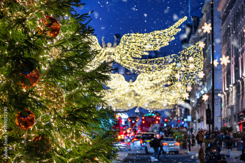 Christmas decorations in central London, England, during night time with blurred street traffic and fairy lights from a tree<