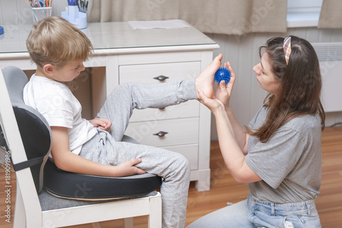 Fotografía Mother using a spiky massage ball for son to relieve muscle tension, aid recovery after training