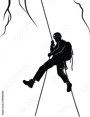 Silhouette of climber rappelling on rope with backpack and helmet