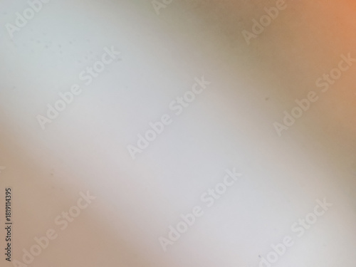 Abstract background of a simple, smooth door surface intentionally blurred. Soft, white and gray gradient transitions with a hint of warm orange color.