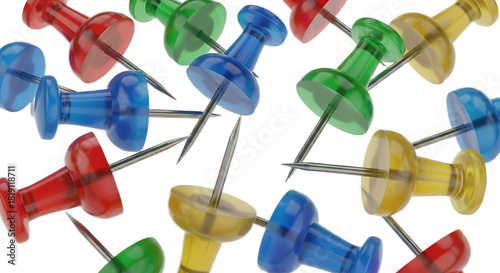 A close up shot of an assortment of colorful push pins scattered across a plain background surface