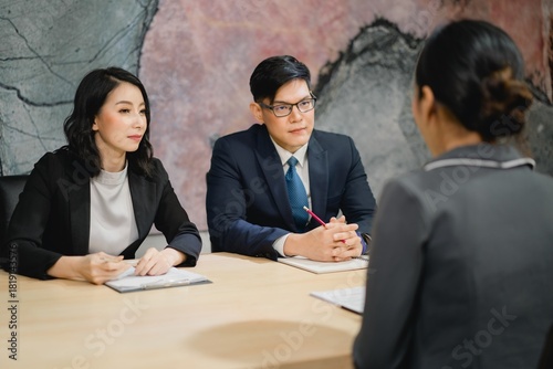 Executive panel performing professional assessment, demonstrating active listening, intense focus, and critical evaluation during a formal interview
