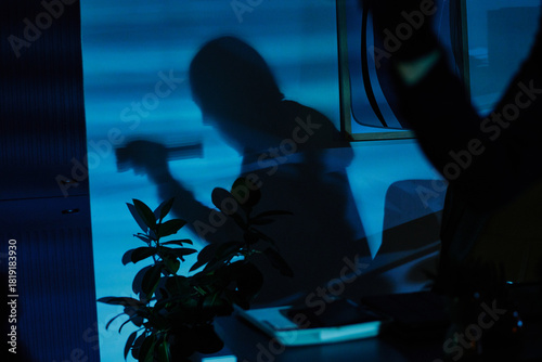 Photos Silhouette of young adult man holding flashlight projected on office wall, shado