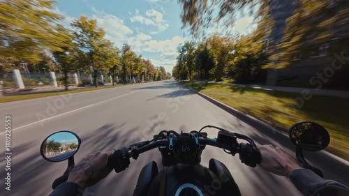 POV motorcycle riding on a rural road. First-person view of handlebars and dashboard with golden sun glare and people on the roadside.