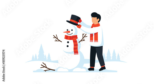 Young man wearing a scarf and sweater placing a black top hat on a friendly snowman he just built in a winter landscape.