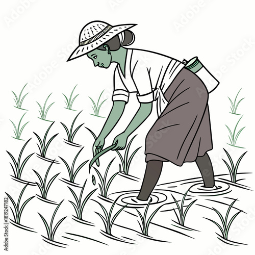A farmer wearing a straw hat plants rice seedlings in a flooded paddy field with a tool