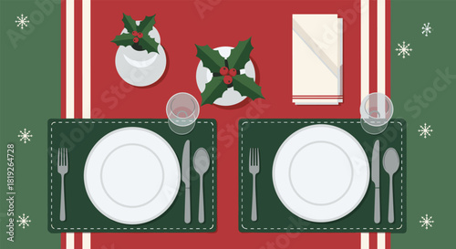 Top-down view of a festive Christmas dinner table setting for two with plates, holly, and snowflake decorations.