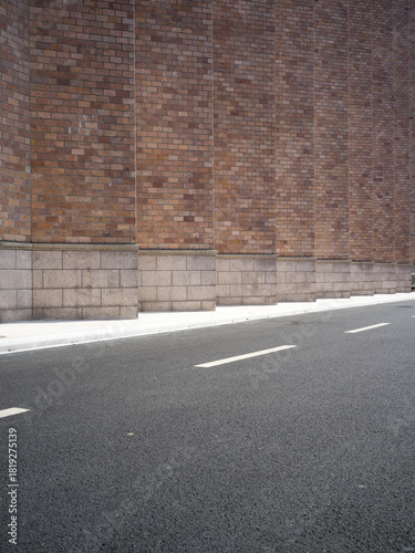 Fototapeta Naklejka Na Ścianę i Meble -  Brick building, paved road, small vents and street lamp